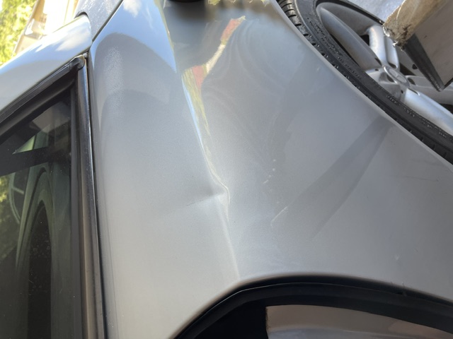 Light silver rear quarter panel with a crease below the window