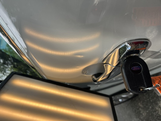 White door panel and handle under a PDR reflection board